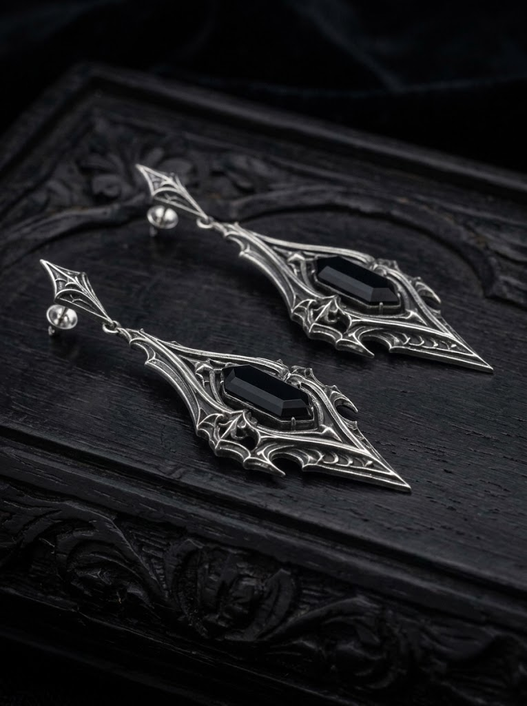 kurgaatelier oxidized 925 sterling silver gothic drop earrings resting on vintage carved surface for alternative witchy jewelry aesthetic