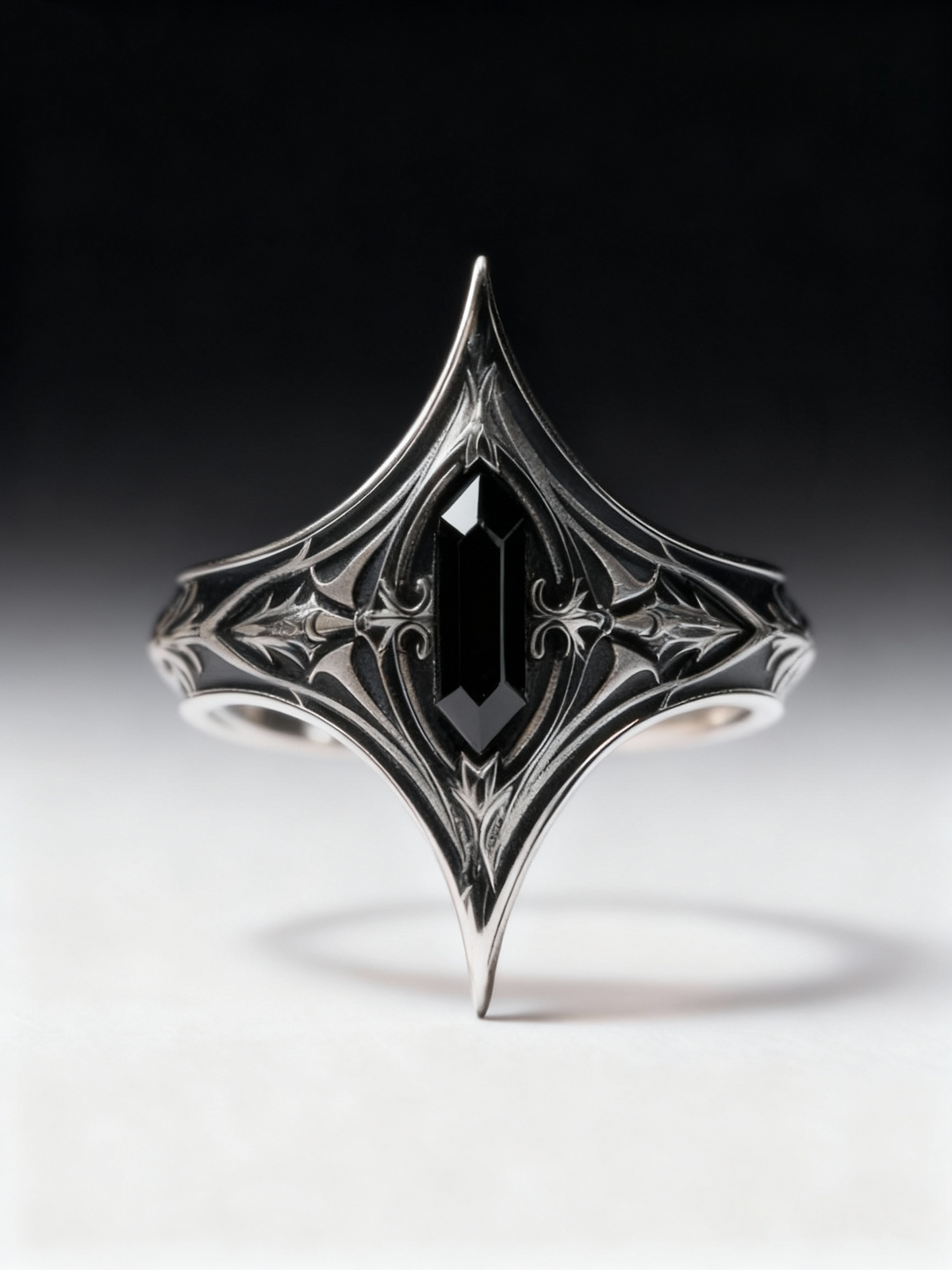 Front view of Kurga Atelier gothic black onyx silver ring on white gradient background, highlighting the pointed cathedral armor design and oxidized finish.