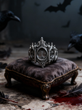 Kurga Atelier gothic cathedral window ring in oxidized sterling silver resting on a vintage velvet cushion with dark aesthetic feathers, gothic wedding ring.