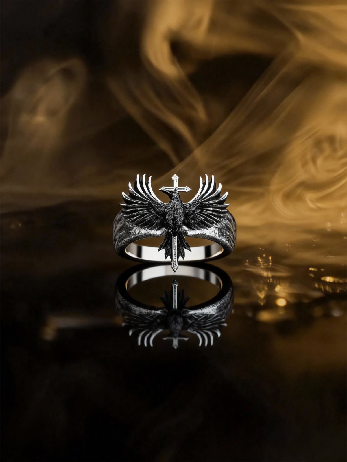 Kurga Atelier gothic raven cross ring displayed on a dark reflective surface with golden ambient smoke and low-key atmospheric lighting.