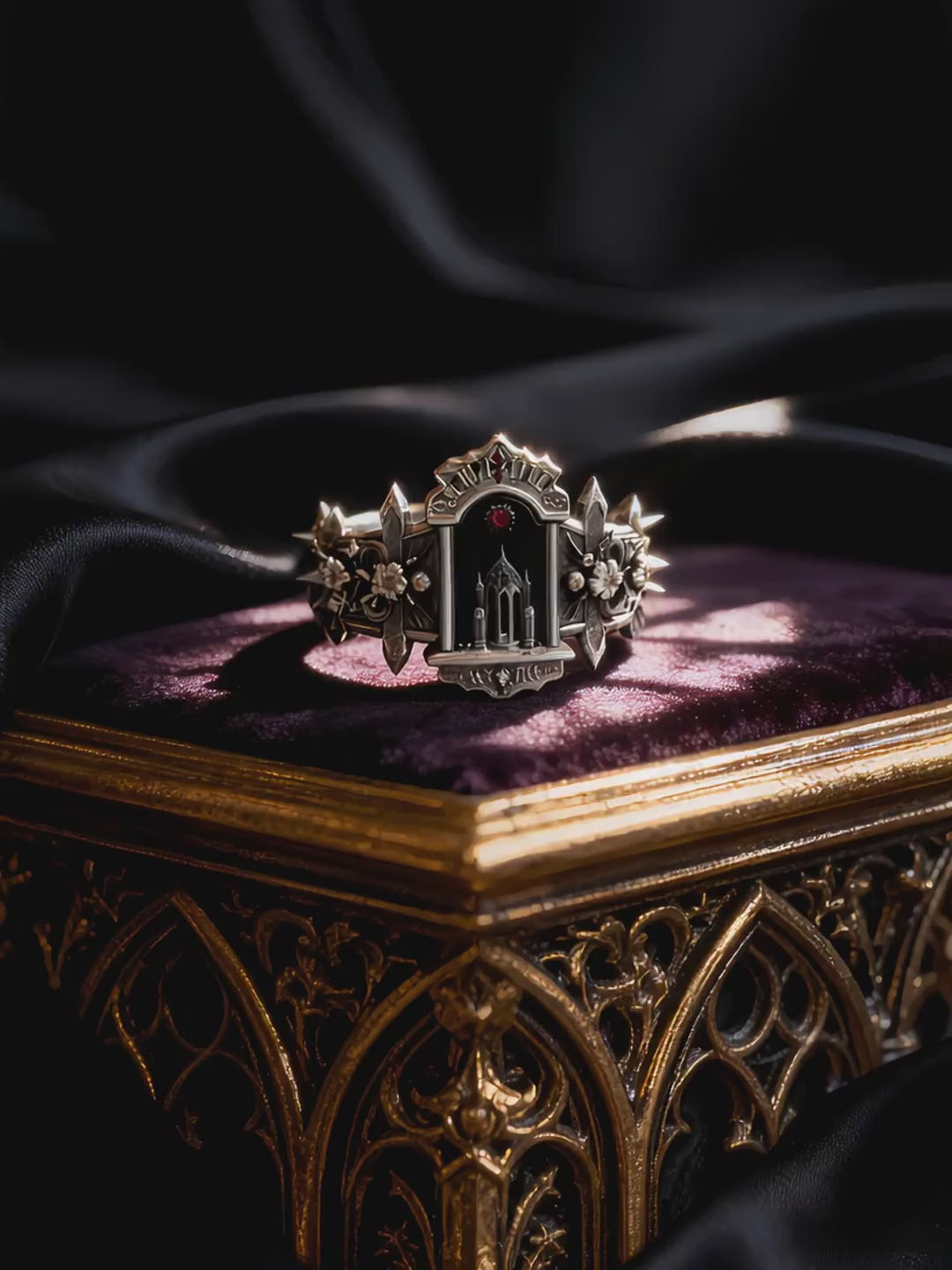 Video showcasing a silver gothic cathedral ring resting on a luxurious purple velvet display stand.
