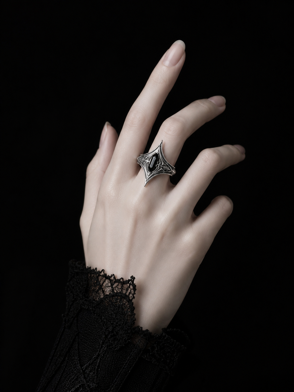 Kurga Atelier gothic black onyx silver statement ring worn on hand with black lace cuff. Pointed armor ring featuring medieval dark academia aesthetic.