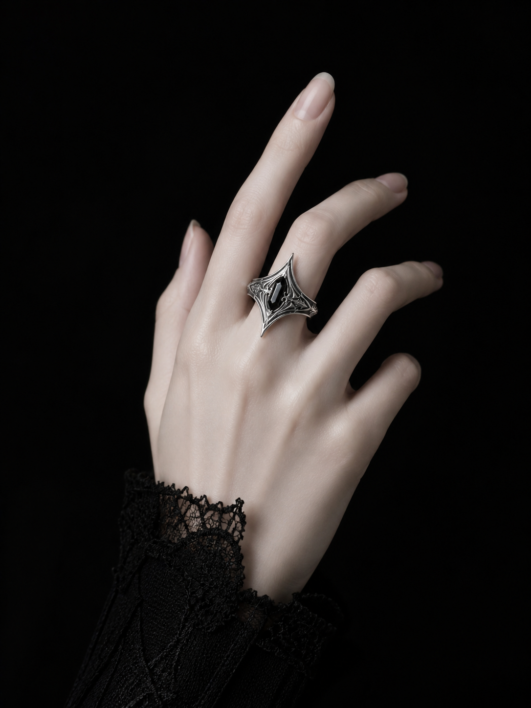 Kurga Atelier gothic black onyx silver statement ring worn on hand with black lace cuff. Pointed armor ring featuring medieval dark academia aesthetic.