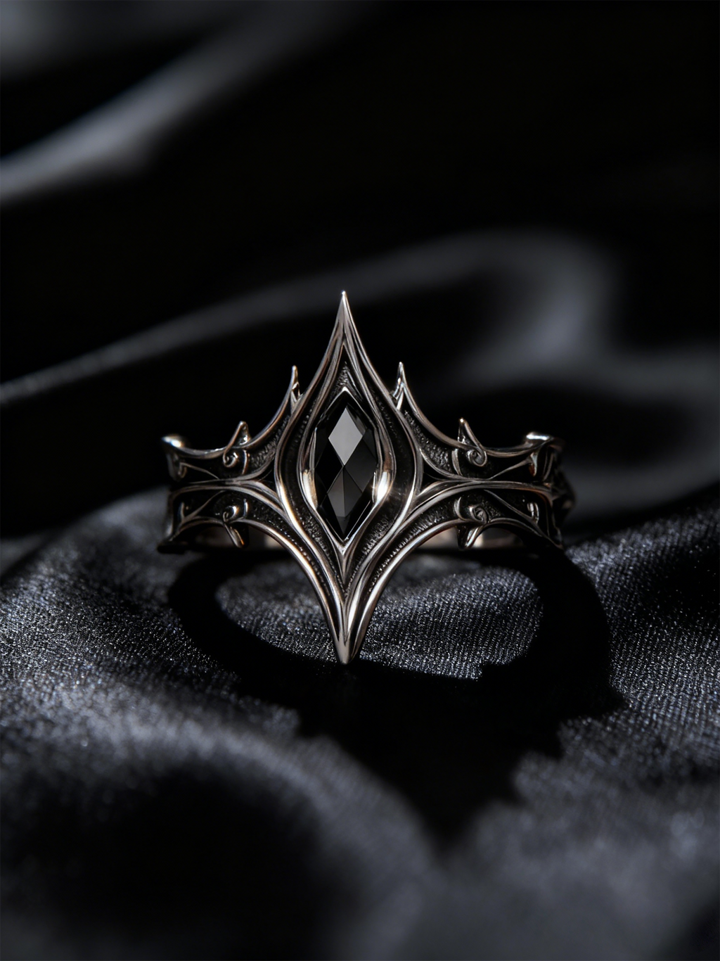 Gothic black onyx crown ring placed on luxurious black silk background, showcasing Victorian architectural arches and silver craftsmanship by Kurga Atelier.