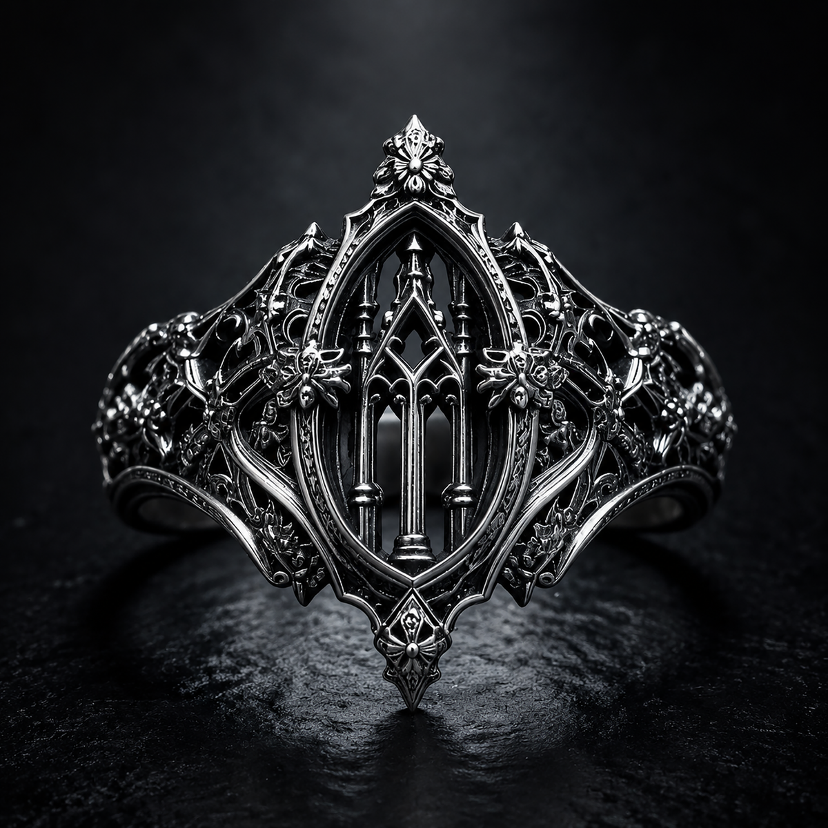High-resolution product shot of Kurga Atelier solid silver gothic cathedral ring on dark stone texture, displaying detailed honeybee reliefs and church arch tracery.